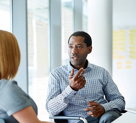 shot of two colleagues talking together in a modern office