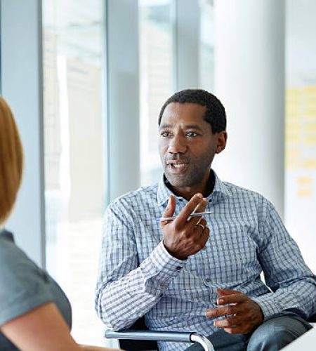 shot of two colleagues talking together in a modern office
