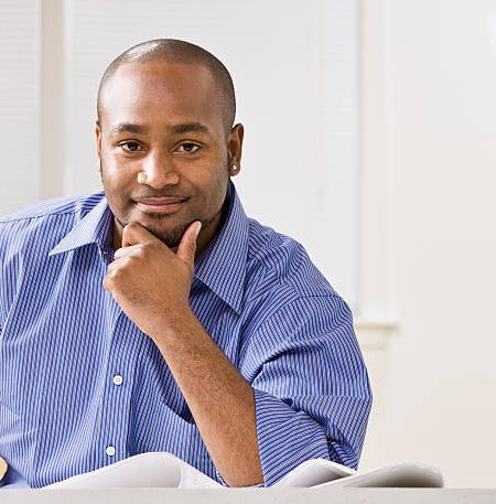 a young businessman is smiling at the camera. horizontally framed shot.