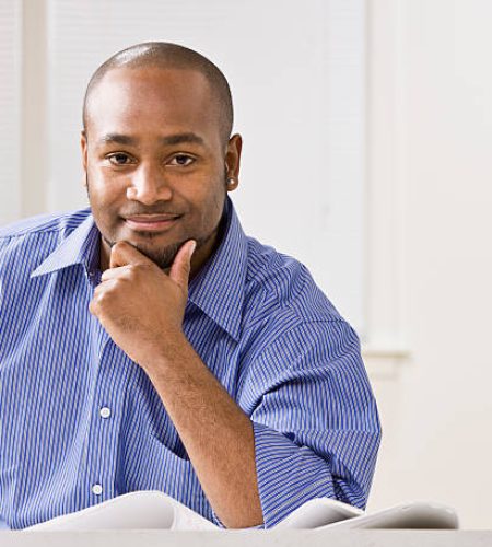 a young businessman is smiling at the camera. horizontally framed shot.