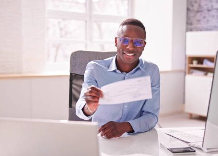 holding paycheck or payroll check or insurance cheque in hand