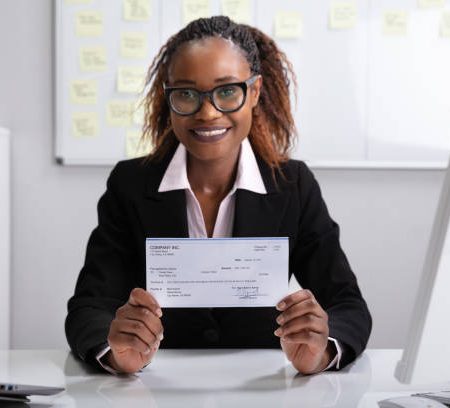 close up of a smiling businesswoman showing company cheque